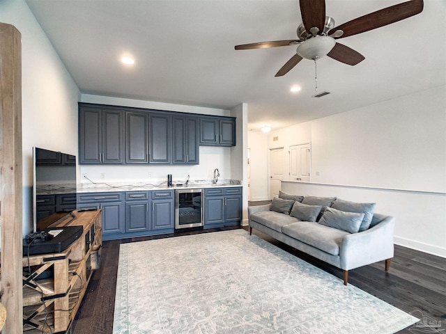 living room with wine cooler, ceiling fan, wet bar, and dark wood-type flooring