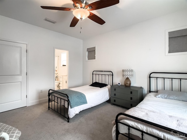 carpeted bedroom with ceiling fan and ensuite bath