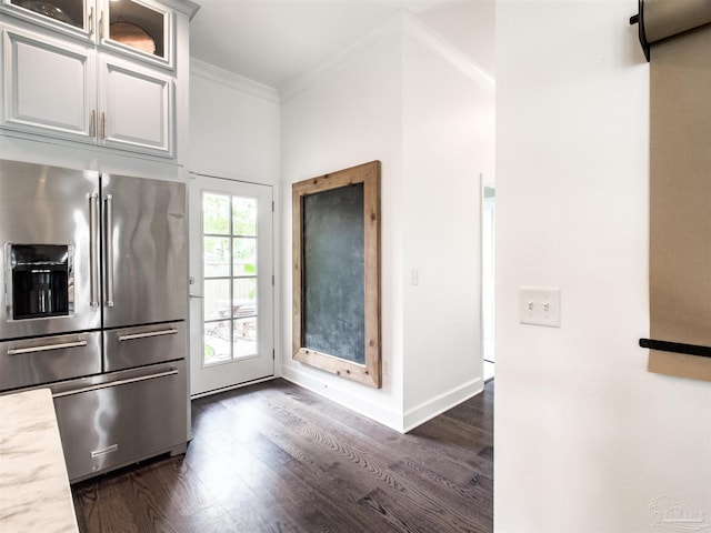 kitchen featuring light stone counters, ornamental molding, dark hardwood / wood-style flooring, and high end fridge