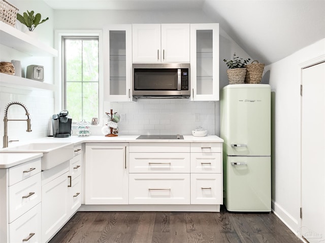 kitchen featuring sink, tasteful backsplash, vaulted ceiling, white fridge, and white cabinets