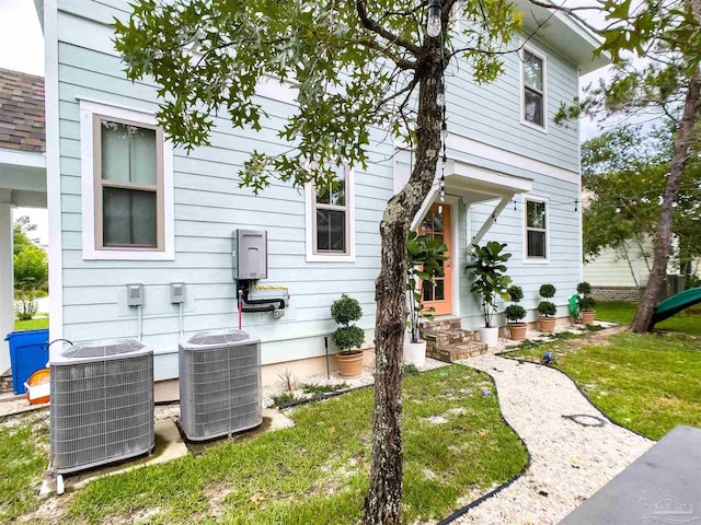 view of property exterior featuring cooling unit and a lawn