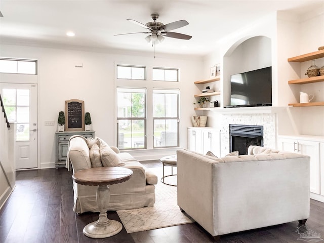 living room with ceiling fan, dark hardwood / wood-style flooring, and built in shelves