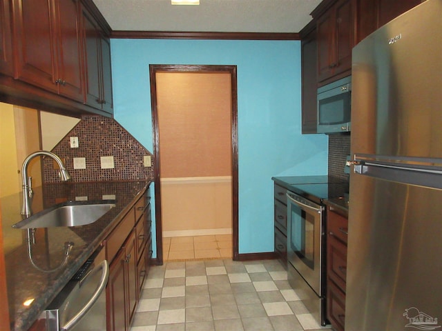 kitchen featuring appliances with stainless steel finishes, crown molding, dark stone countertops, and sink