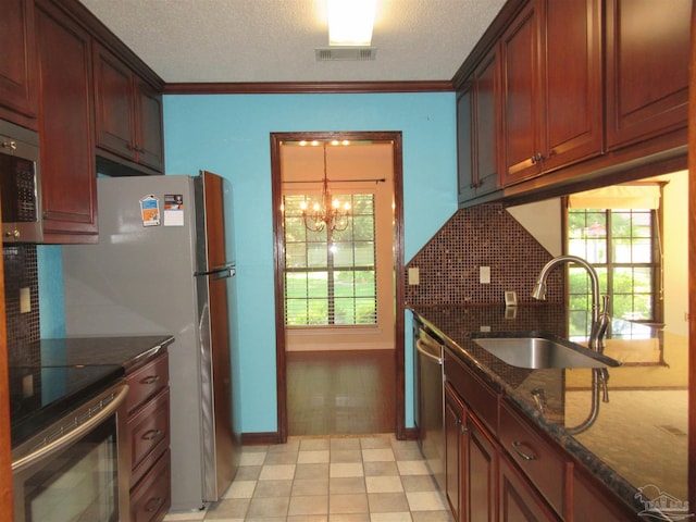 kitchen featuring appliances with stainless steel finishes, ornamental molding, plenty of natural light, and sink