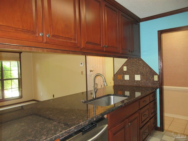 kitchen with dishwasher, dark stone countertops, sink, backsplash, and light tile patterned floors