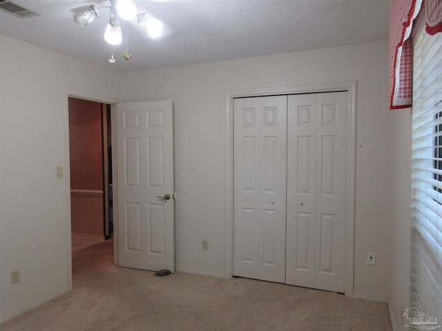 unfurnished bedroom with light carpet, a closet, and ceiling fan