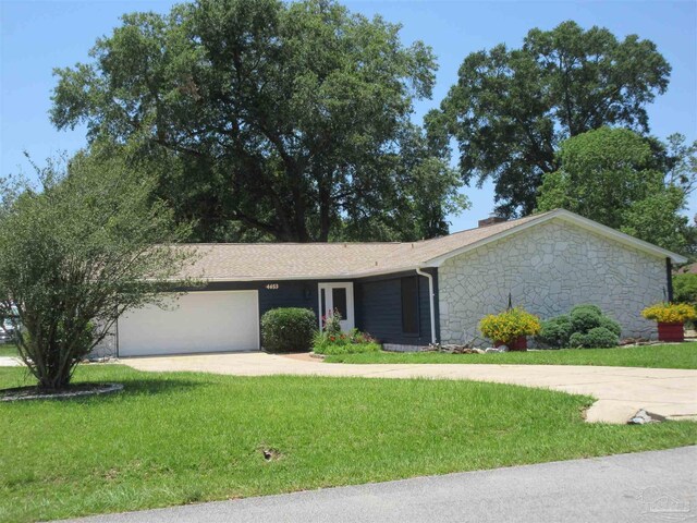 ranch-style house with a garage and a front lawn