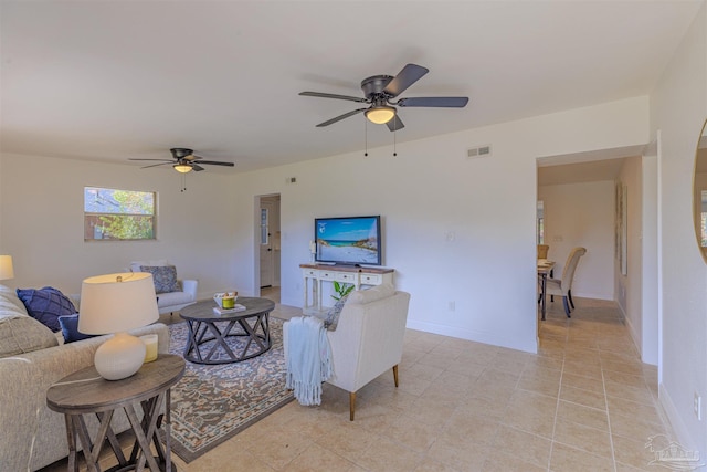 living area with light tile patterned floors, visible vents, baseboards, and a ceiling fan