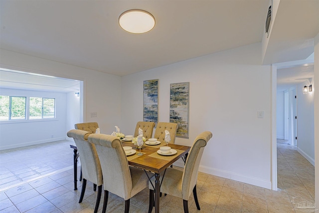 dining room with light tile patterned flooring and baseboards