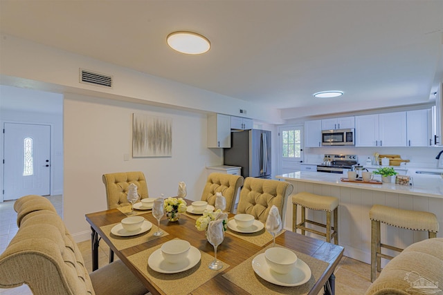 dining space with light tile patterned floors and visible vents