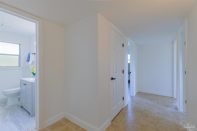 hall with visible vents and baseboards