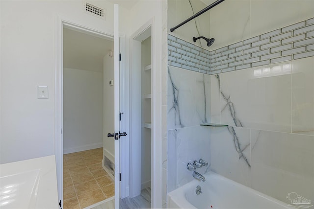 bathroom with visible vents and  shower combination