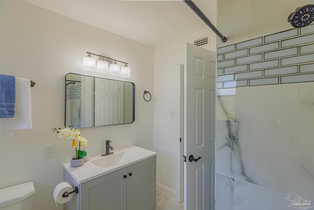 full bath with visible vents, vanity, toilet, and a shower