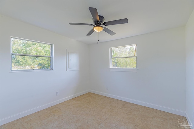 unfurnished room with ceiling fan and baseboards