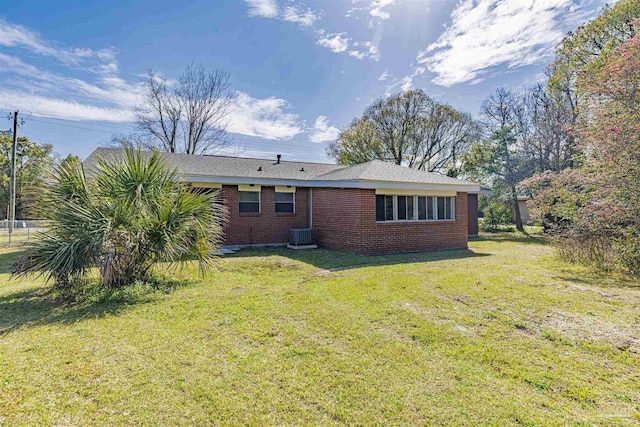 back of house with a lawn and brick siding