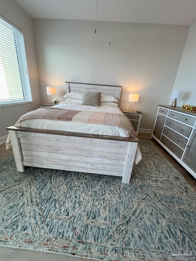 bedroom featuring baseboards and wood finished floors