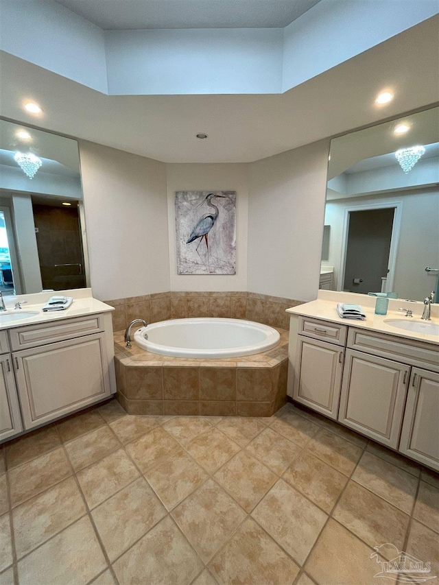 bathroom with a bath, a shower stall, tile patterned floors, two vanities, and a sink