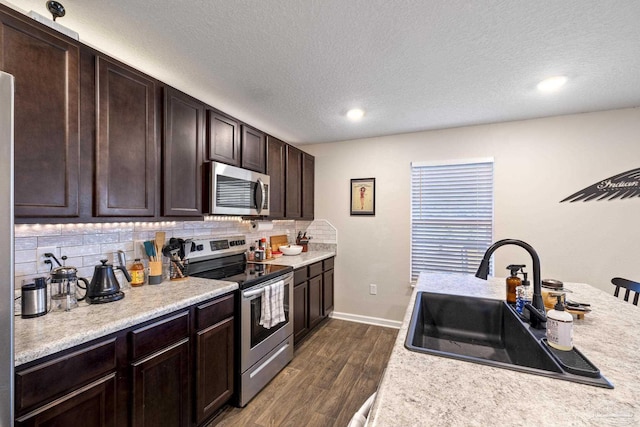 4678 Perception Cir, Milton, FL 32570 - kitchen with appliances with stainless steel finishes, a sink, light countertops, dark brown cabinetry, and dark wood finished floors