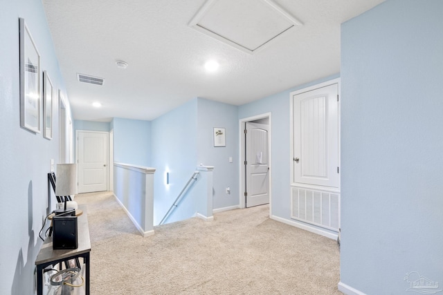 4678 Perception Cir, Milton, FL 32570 - hall with an upstairs landing, carpet floors, baseboards, a textured ceiling, and attic access