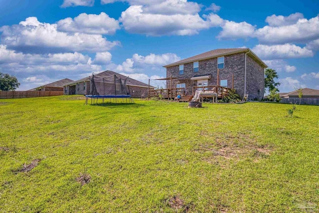 4678 Perception Cir, Milton, FL 32570 - back of property with a trampoline, a wooden deck, and brick siding