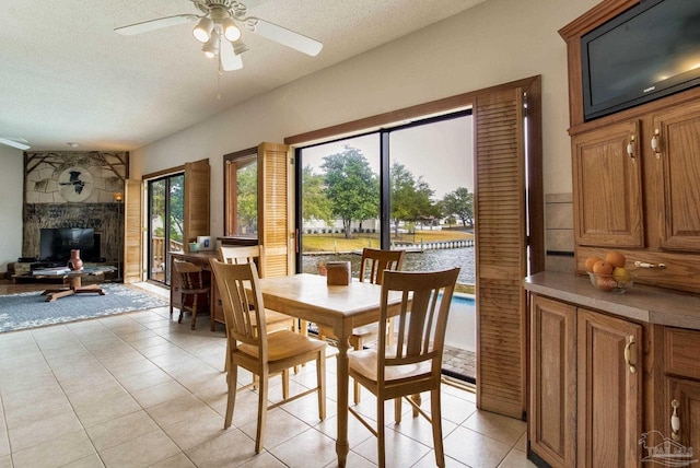 dining area featuring ceiling fan, a textured ceiling, and light tile patterned floors