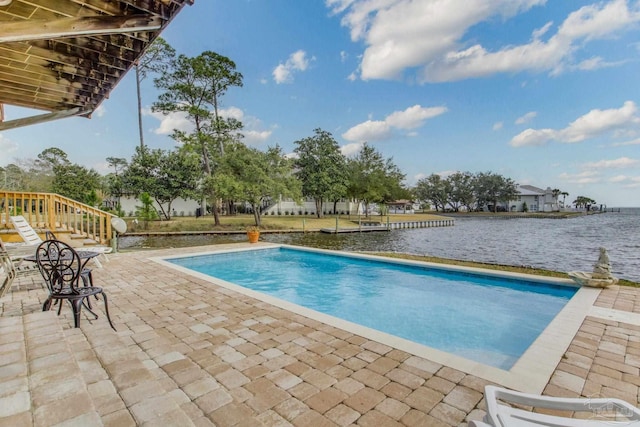 outdoor pool with a patio area and a water view