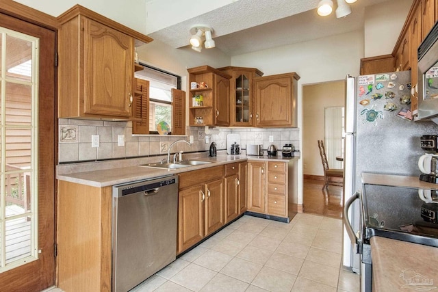 kitchen featuring electric stove, dishwasher, backsplash, light countertops, and a sink