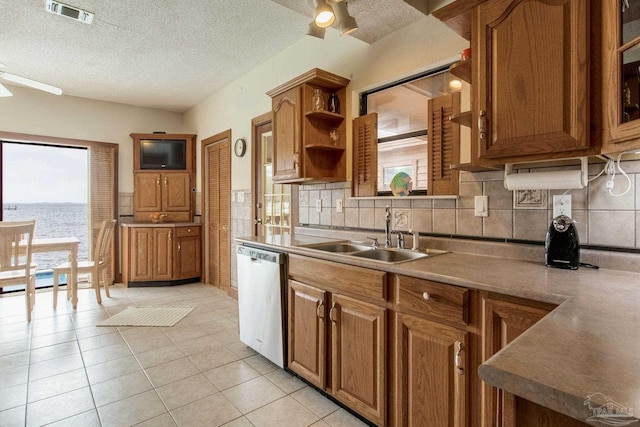 kitchen with a sink, visible vents, dishwasher, open shelves, and brown cabinetry