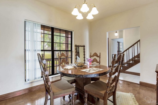 dining space featuring a chandelier, stairway, baseboards, and wood finished floors