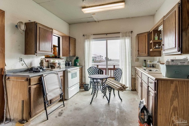 kitchen featuring unfinished concrete flooring, open shelves, electric stove, and light countertops