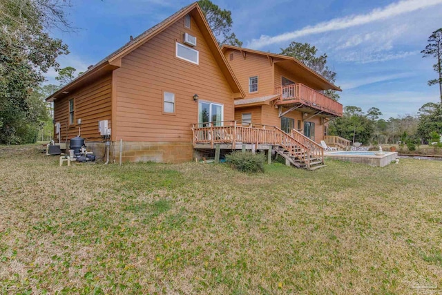 rear view of house with a deck, a yard, a balcony, and an outdoor pool