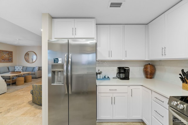 kitchen with white cabinets, backsplash, and stainless steel appliances