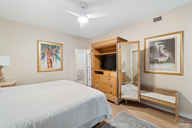 bedroom featuring ceiling fan, light hardwood / wood-style floors, and ensuite bath