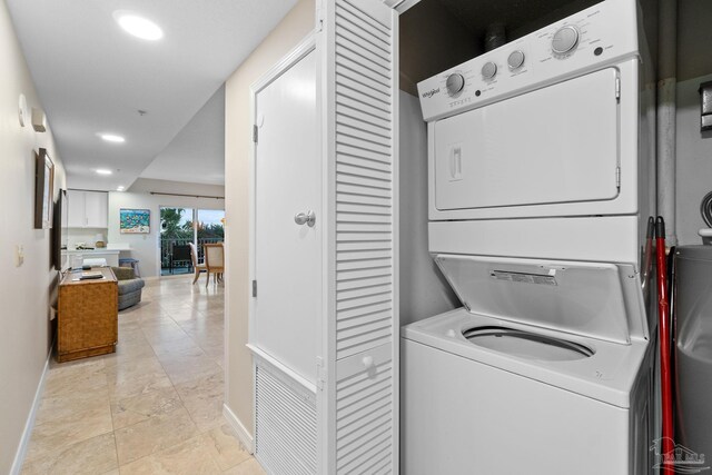 washroom with light tile patterned floors and stacked washer and clothes dryer