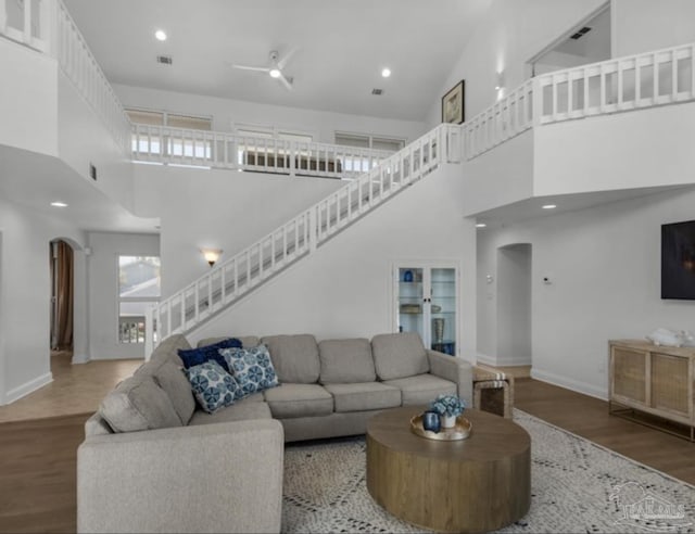 living room featuring wood-type flooring and a towering ceiling