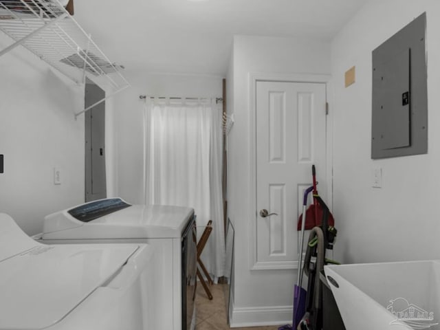 washroom featuring sink, light tile patterned floors, electric panel, and washing machine and dryer