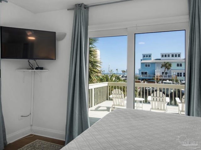 bedroom with access to exterior and dark hardwood / wood-style flooring