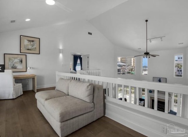 living room with lofted ceiling, dark wood-type flooring, and rail lighting