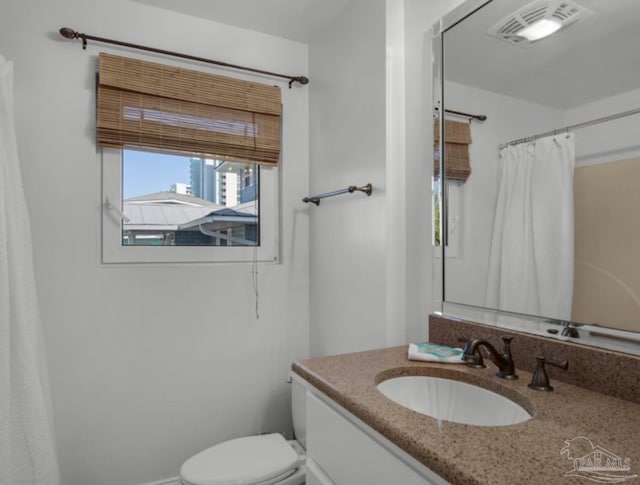 bathroom featuring a shower with curtain, vanity, and toilet