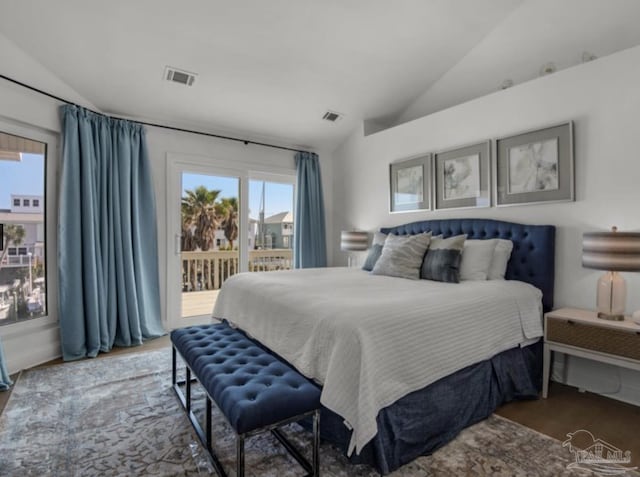 bedroom featuring multiple windows, vaulted ceiling, wood-type flooring, and access to exterior