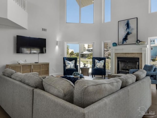 living room featuring a tiled fireplace and dark wood-type flooring