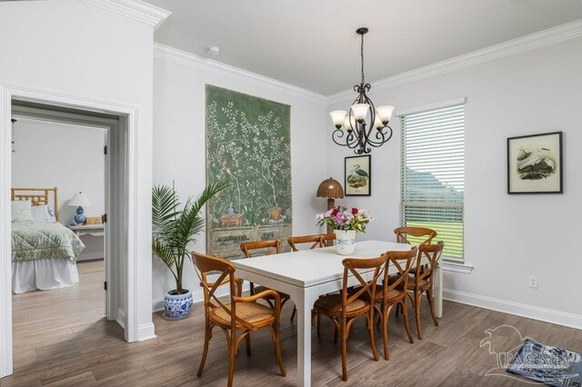 2929 Trestle Way, Cantonment, FL 32533 - dining space featuring crown molding, baseboards, an inviting chandelier, and dark wood-style floors