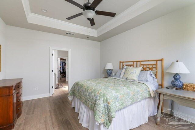 2929 Trestle Way, Cantonment, FL 32533 - bedroom with visible vents, ornamental molding, wood finished floors, and a tray ceiling