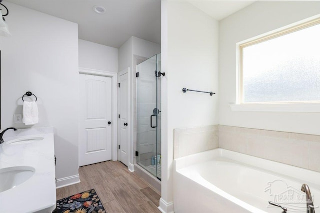 2929 Trestle Way, Cantonment, FL 32533 - full bath featuring a sink, baseboards, a shower stall, wood finished floors, and a garden tub