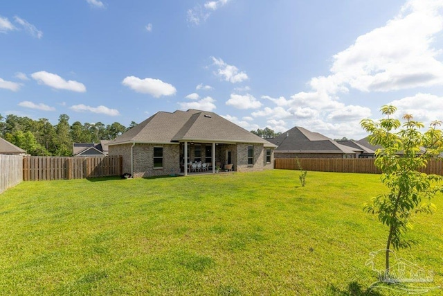 2929 Trestle Way, Cantonment, FL 32533 - rear view of house featuring a fenced backyard, a yard, and brick siding