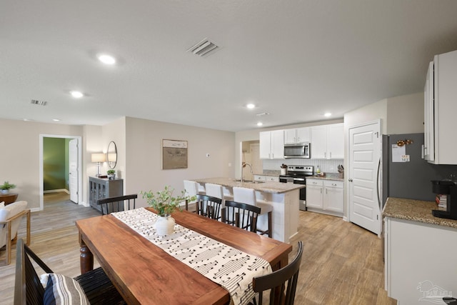 5711 Guinevere Ln, Milton, FL 32583 - dining space with visible vents, light wood finished floors, and recessed lighting