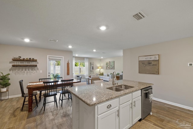5711 Guinevere Ln, Milton, FL 32583 - kitchen with visible vents, a center island with sink, stainless steel dishwasher, a sink, and wood finished floors