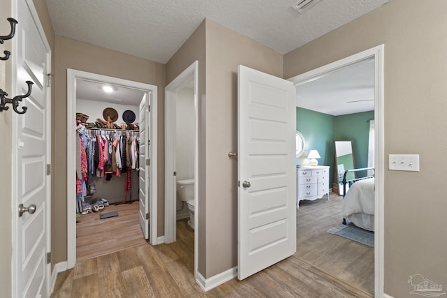 5711 Guinevere Ln, Milton, FL 32583 - corridor featuring light wood-type flooring, baseboards, and a textured ceiling