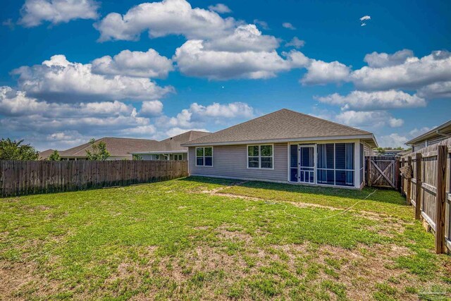 5711 Guinevere Ln, Milton, FL 32583 - rear view of house with a fenced backyard, a sunroom, and a lawn