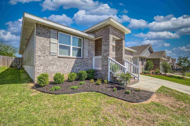 5711 Guinevere Ln, Milton, FL 32583 - view of front of house with brick siding, fence, and a front lawn